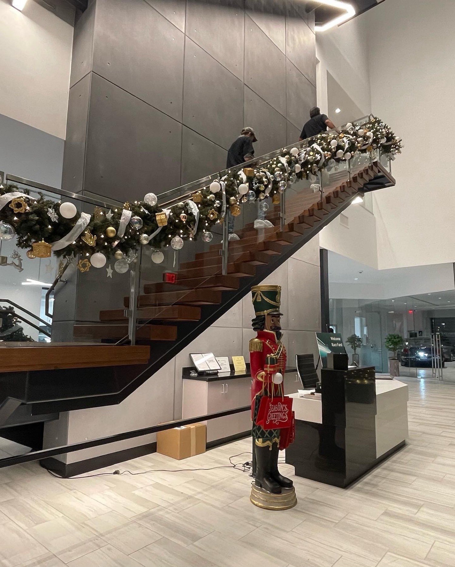 Commercial lobby stair garland with ornaments and a life-size nutcracker